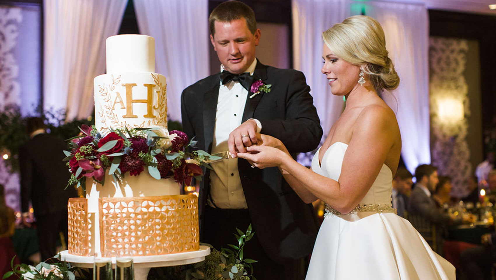 bride and groom cut wedding cake together in ballroom at Kimpton Tryon Park Hotel