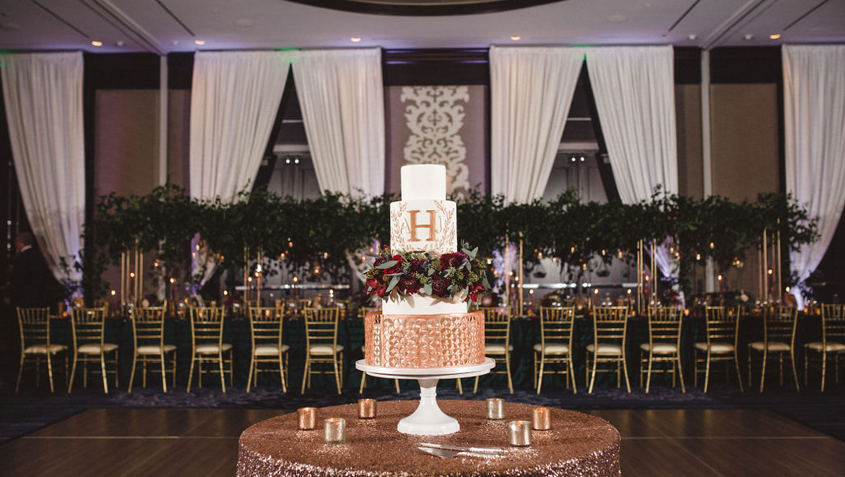 close up of wedding cake with wedding reception tables in the background in ballroom at Kimpton Tryon Park Hotel