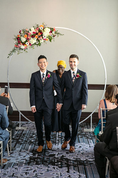 recently married couple walking down the aisle holding hands.