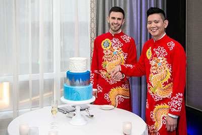 couple cutting wedding cake together.