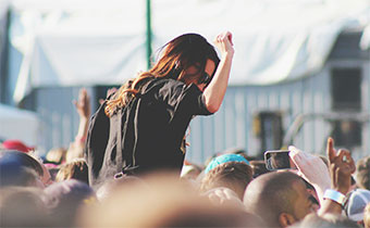 woman at live show on someone’s shoulders