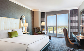 king guestroom with desk, chair and view of Charlotte at Kimpton Tryon Park Hotel
